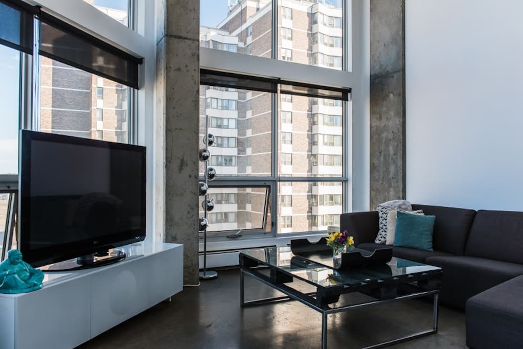 Spacious and bright living room with a view of the river. Lounge on this huge EQ3 sectional couch and enjoy your favorite shows on this 50" tv with cable.