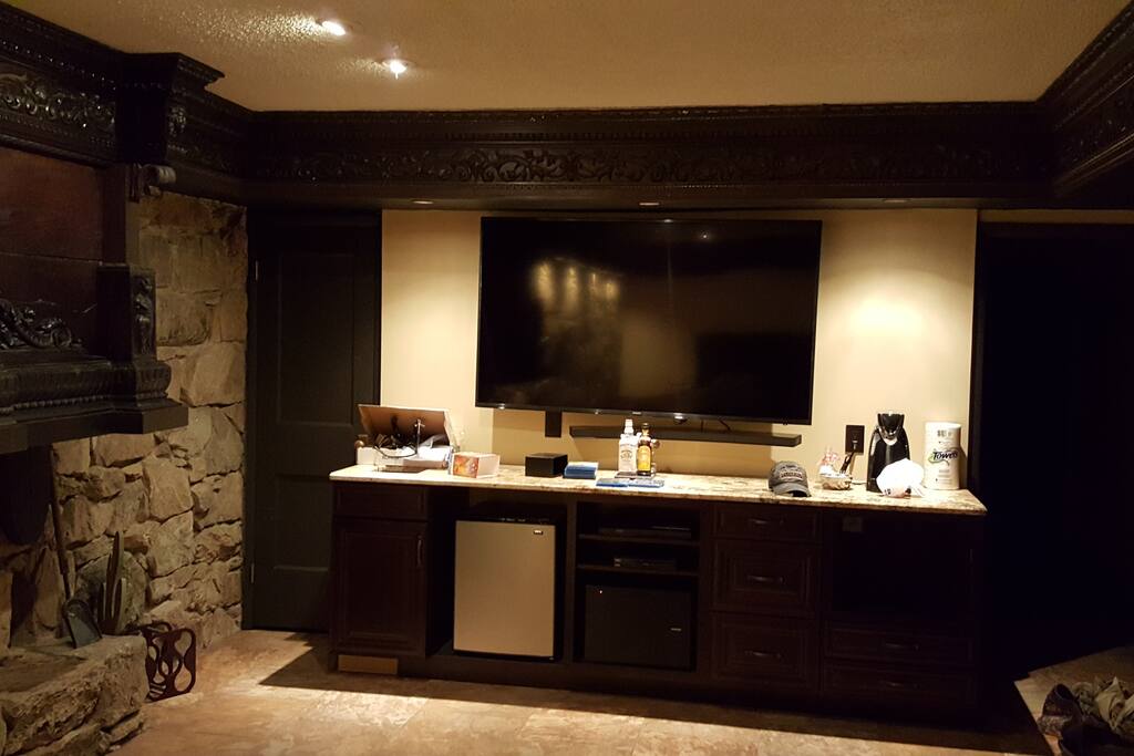 70 inch TV over fully stocked kitchenette.