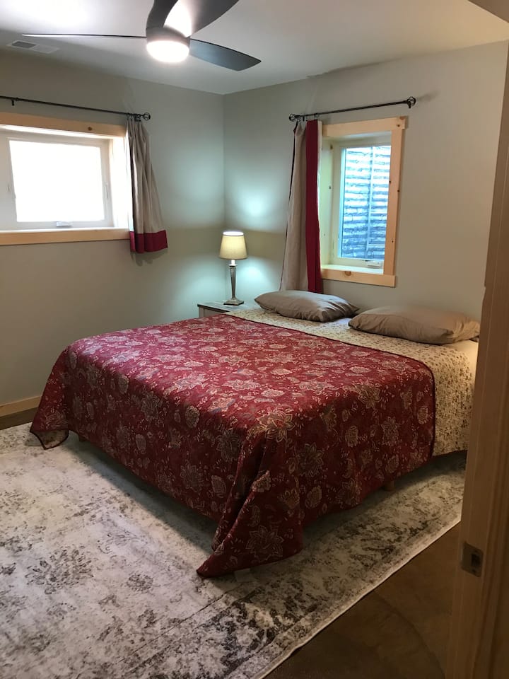 חדר שינה בקומה התחתונה עם מיטת קינג סייז.