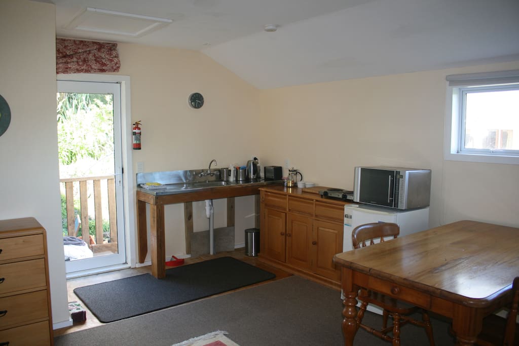 Fully equipped kitchenette area with fridge, cooktop, kettle, toaster, microwave and small oven.