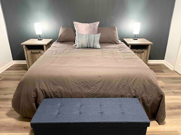 חדר השינה הקדמי כולל מיטת קווין סייז, 2 שידות צדדיות עם אורות, ספסל עם אחסון, טלוויזיית Fire HD 43 אינץ' ו -2 ארונות עם קולבים. 