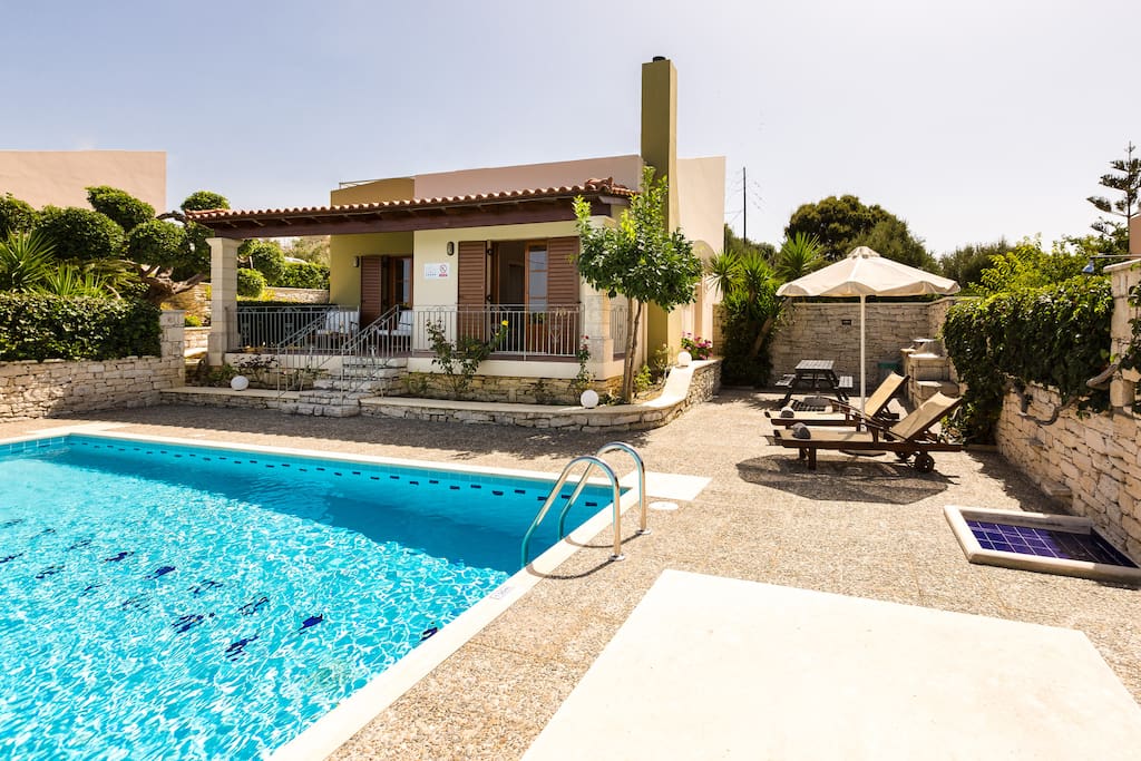 Outdoor area of our villa with pool, sun beds, barbecue & sitting areas