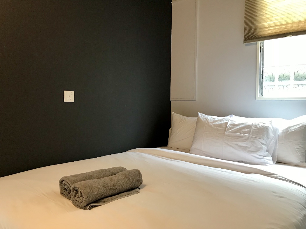 Cap 3 (Ground Level): Small Backpacker Sized Bedroom with 1 Hotel Standard Queen Bed, with Shared Bathroom Outside The Room