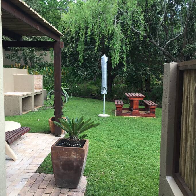 Beautiful garden with barbecue and picnic table with umbrella
