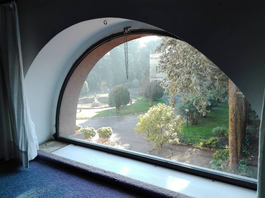 La grande finestra a mezzaluna si affaccia sul giardino all'italiana
