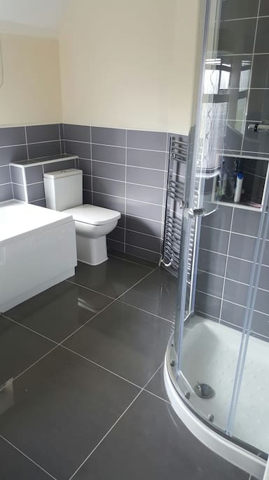 Brand new bathroom with shower cubicle and separate bath