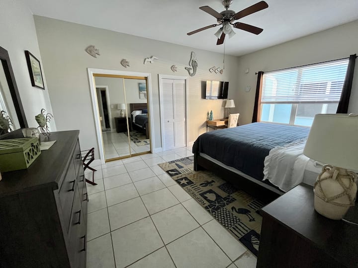 Chumba cha kulala kilicho  na kitanda aina ya king, runinga janja, dawati na kabati kubwa la ukubwa.