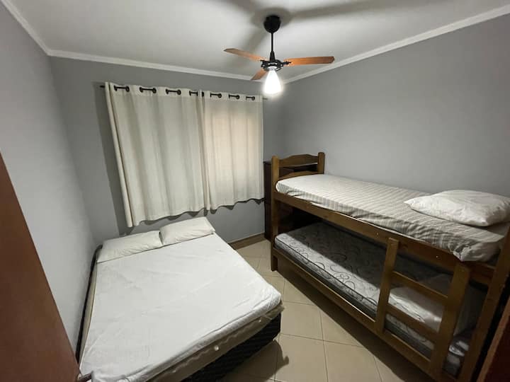 Dormitorio 03: cama doble y litera. Tiene un pequeño armario para guardar ropa, tiene una pantalla mosquetero y un ventilador de techo. 