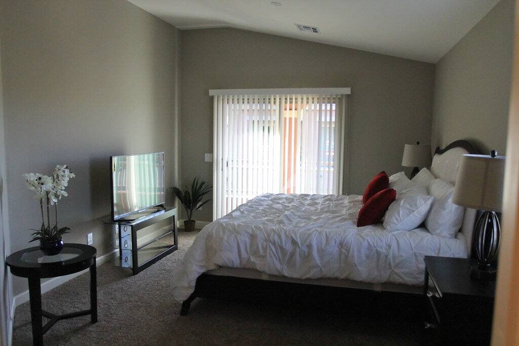 Master suite with comfy king bed, high ceilings, tv, and private bathroom.
