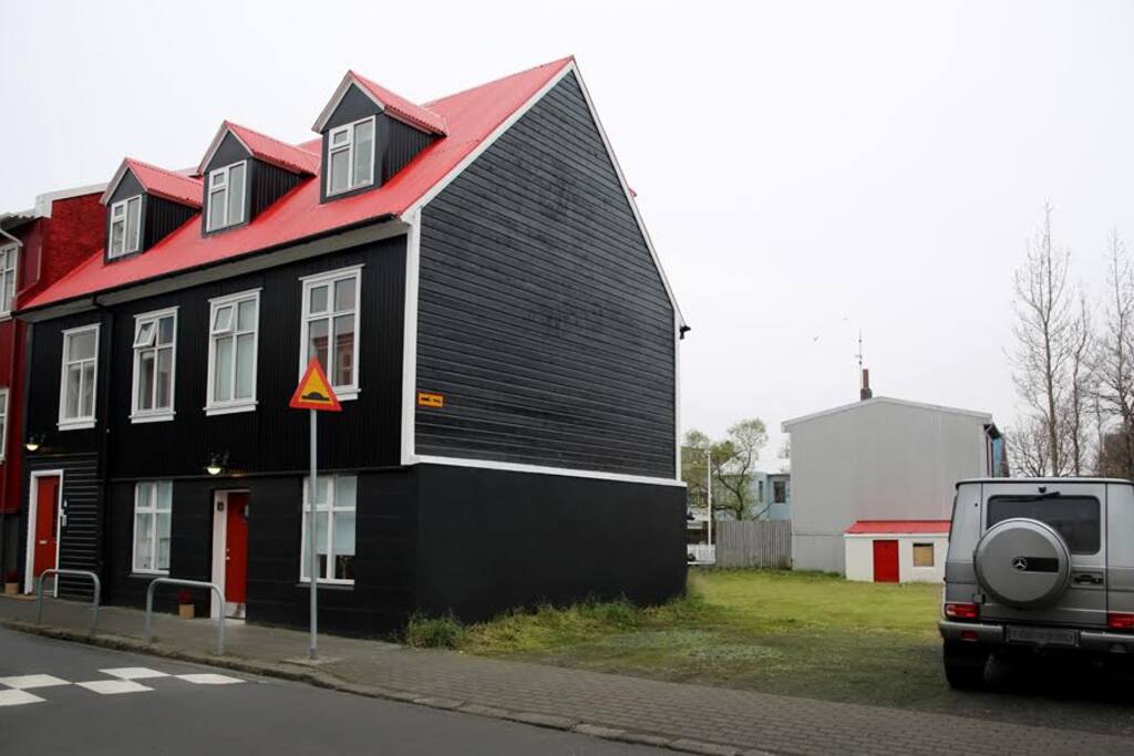 The house is newly painted black with a red roof