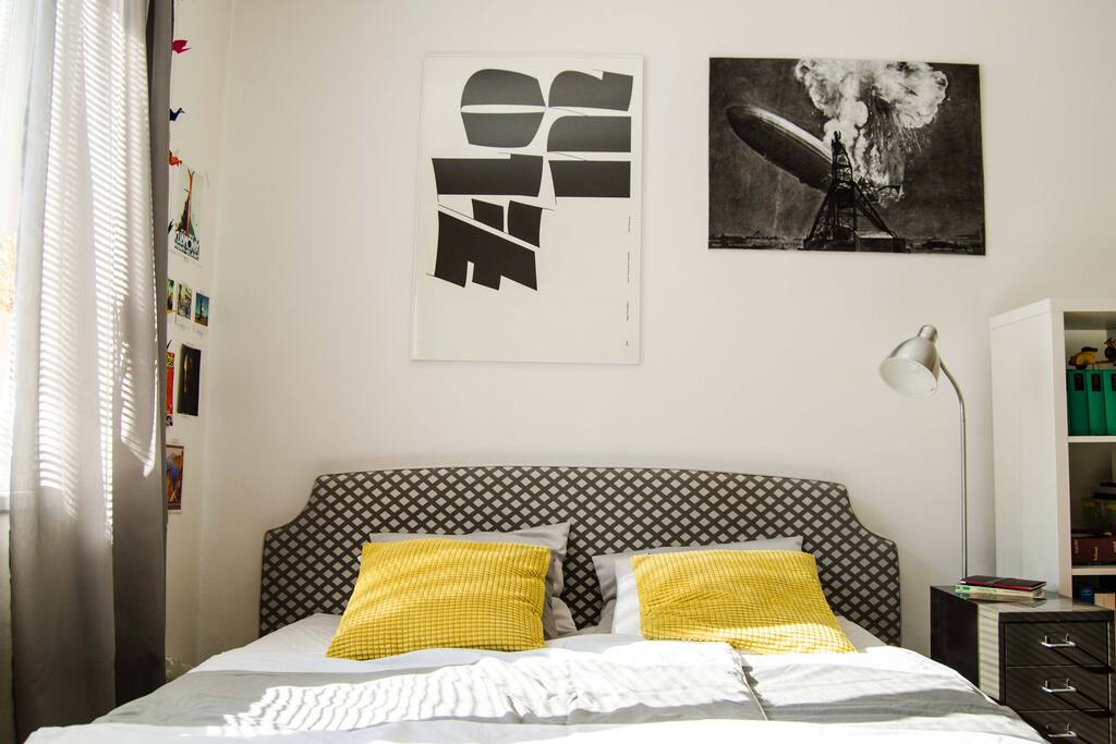 Big comfortable bed with upholstered headboard and fresh linen