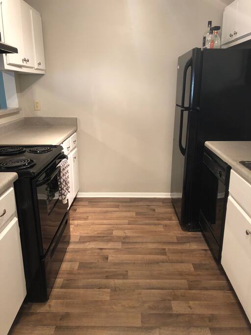 Kitchen with stove, electric kettle, French presses, fridge, and dishwasher