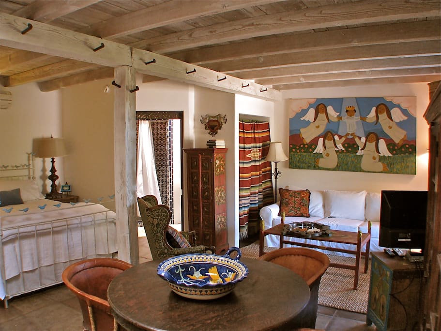 View of bed, bathroom, and sitting area.