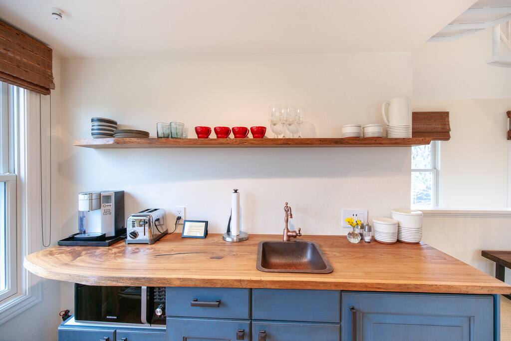 The kitchenette has a sink, fridge with freezer, toaster, Keurig coffee maker, and microwave