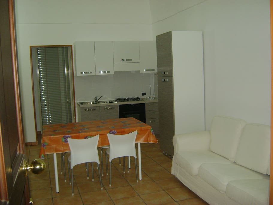 soggiorno con angolo cotture attrezzato e divano letto