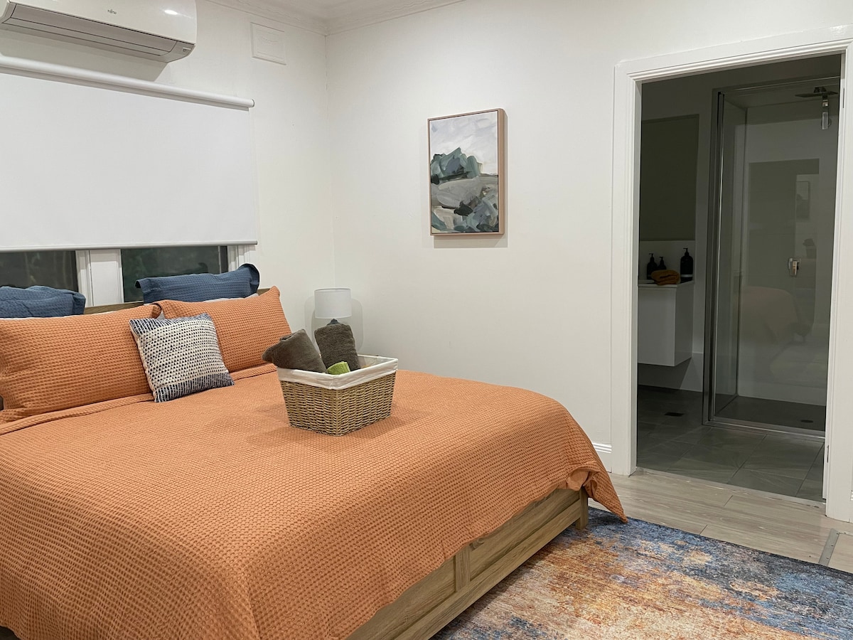 غرفة نوم رئيسية بسرير بحجم كبير وحمام داخلي وغطاء هواء بدورة عكسية