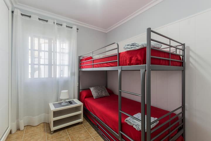 Dormitorio con litera de tres camas