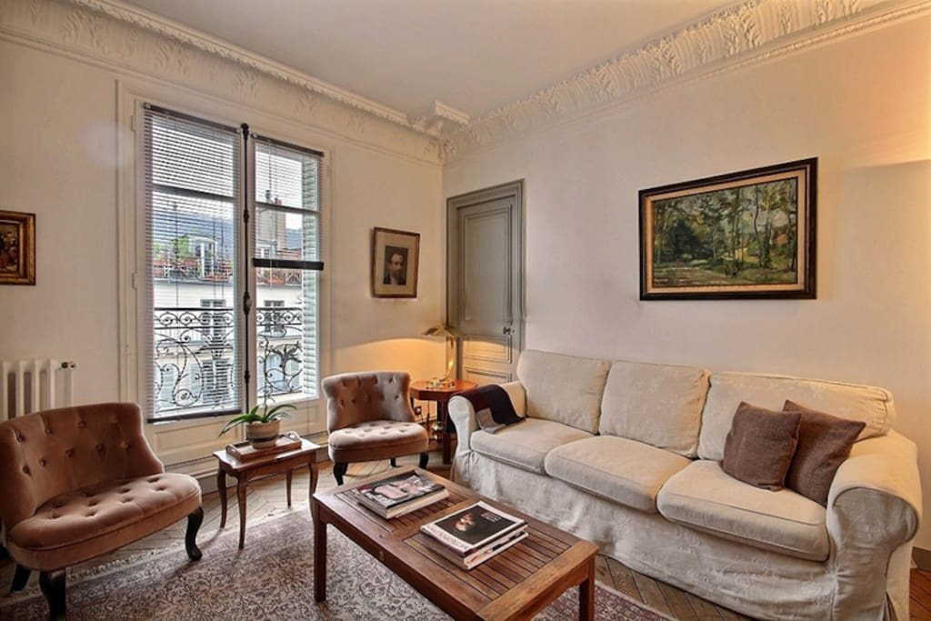 Living
The 13 square meters living room has a double glazed window facing street and leading to the balcony . It is equipped with : sofa, coffee table, cable, TV, phone, 2 armchairs, decorative fireplace, hard wood floor.