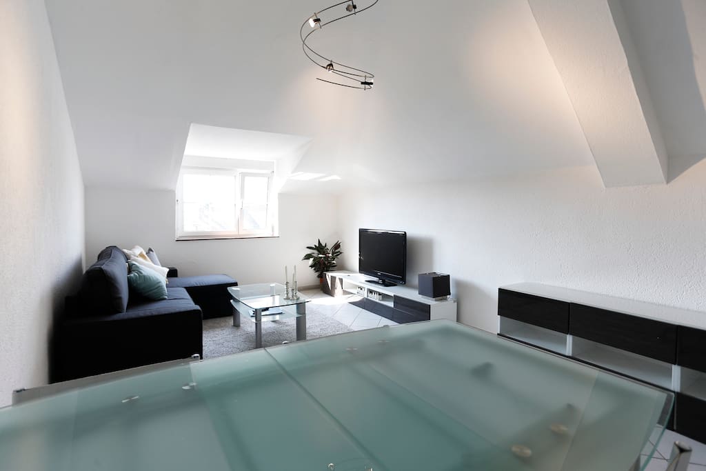Spacious living room with big flat TV and cable.