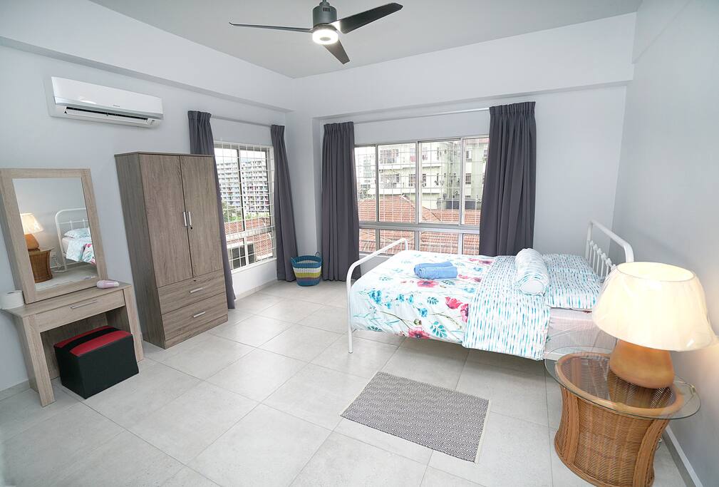 Master bed room with queen size bed. A wardrobe with hangers inside, dressing table and a hair dryer. The room is with attached bathroom with heater shower. There are also multiple socket in the room. 90% sun block curtains.