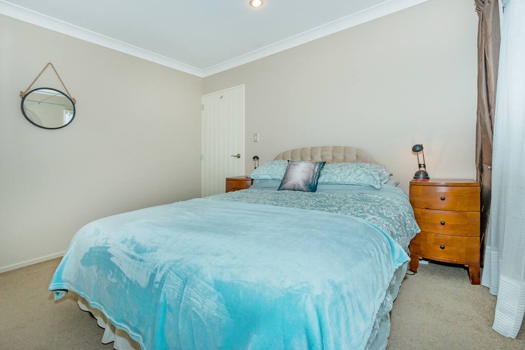 Queen sized bed warm and sunny room.
