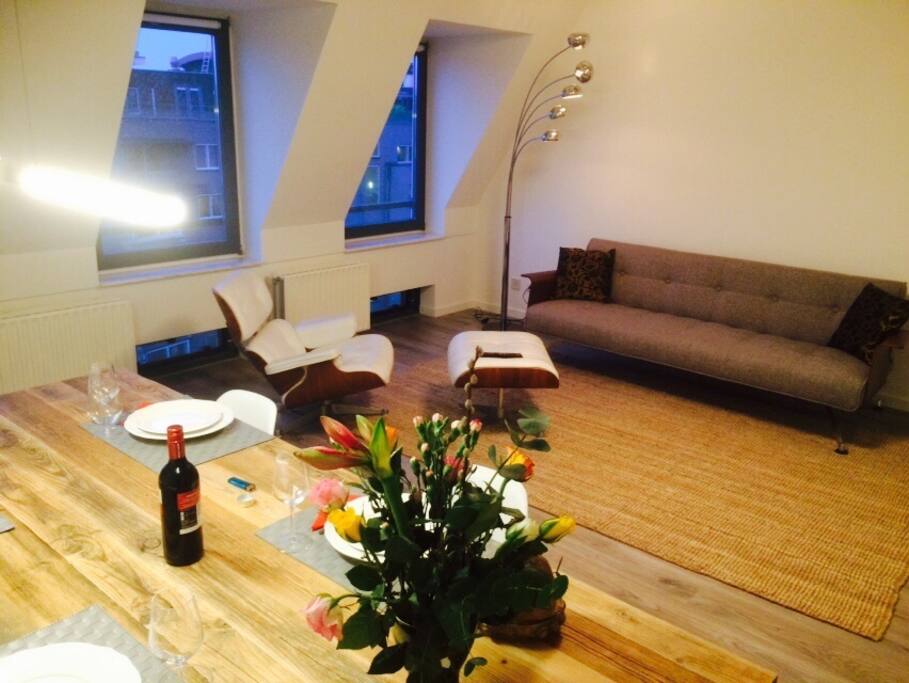 The living area with a sofa, a recliner and a flat screen 50'' cable TV.