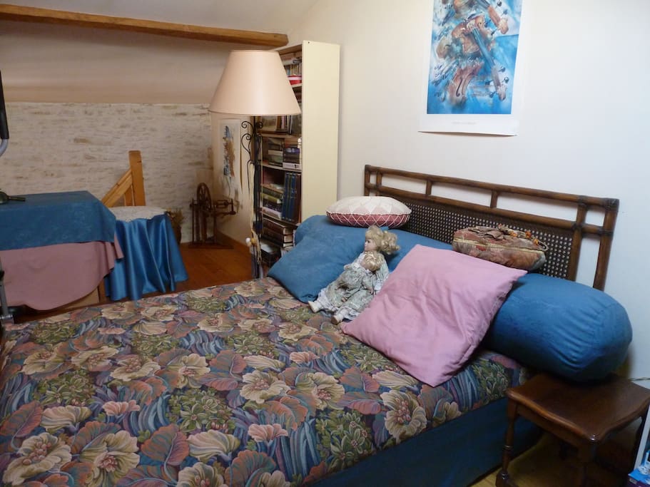 La chambre se situe en mezzanine, au dessus d'un salon séparé du reste de la maison. Lit 2 places, étagères à disposition, bureau et portant.