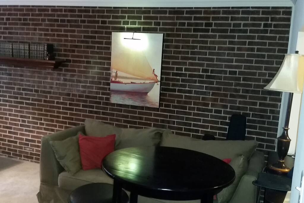 Two person pub table and large, comfy sleeping couch. (other half of living room)