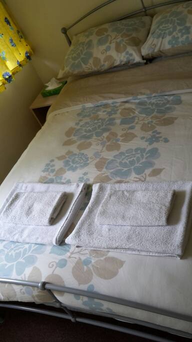 Towels and bed set up for two guests