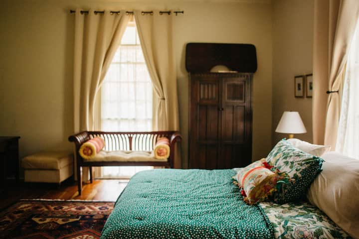 Bedroom 1 has a queen bed and a single bed. Front windows look out to the front porch.