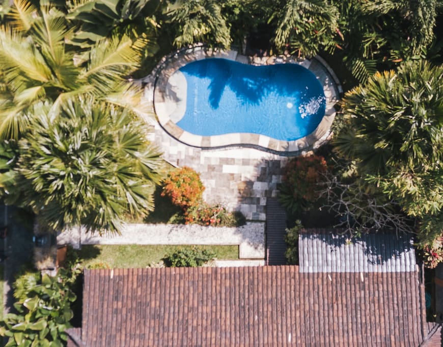 Seen from above, you see the lush garden surrounding the private pool. The pool, clad in deep blue tiles and encircled with tiles made of sand stone is filled with crystal clear water. It is approx. 7m x 2,5m.