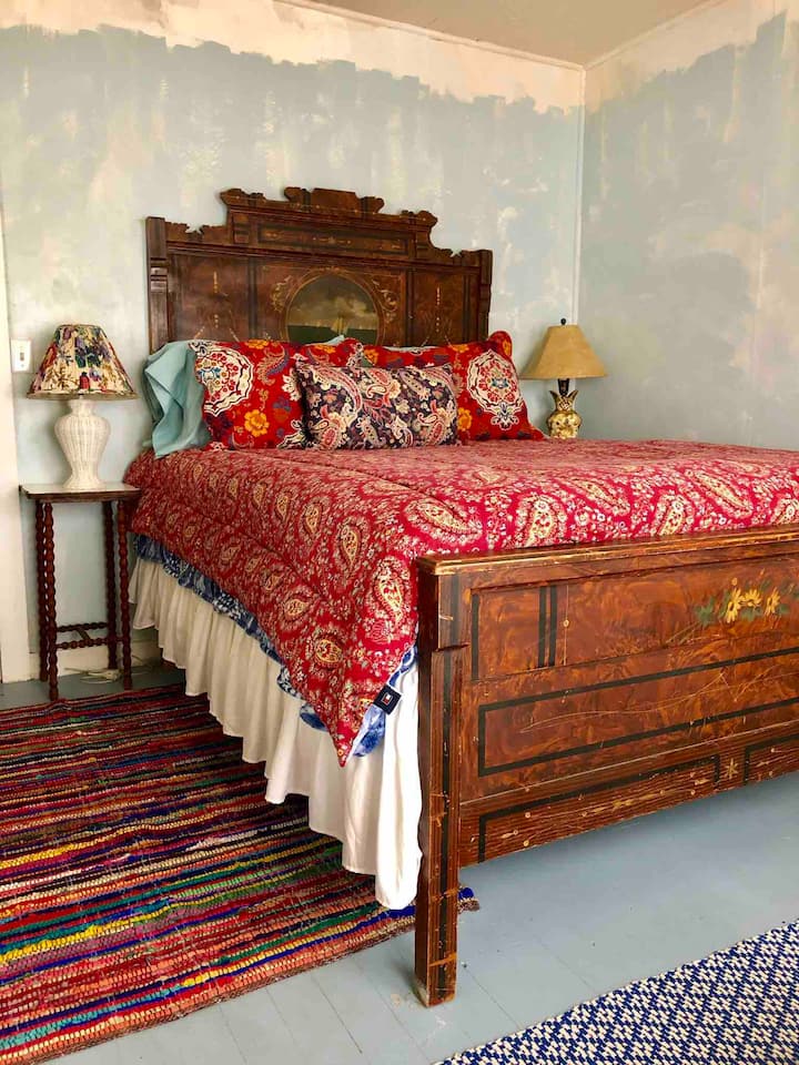 Queen bed with en-suite bathroom. Sweet sailing on the headboard ship gracing this antique “Cottage Furniture” bed, reconfigured for a queen.