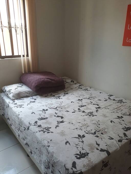 cama casal quarto possui janela e ventilador