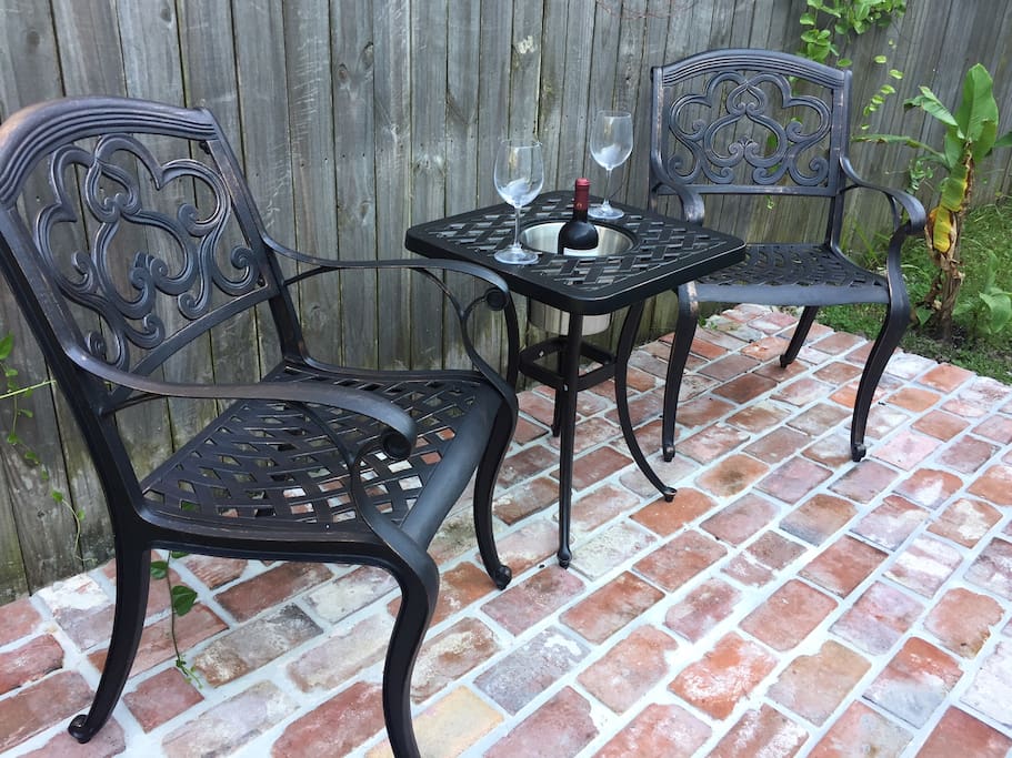 Brick patio seating area in backyard.