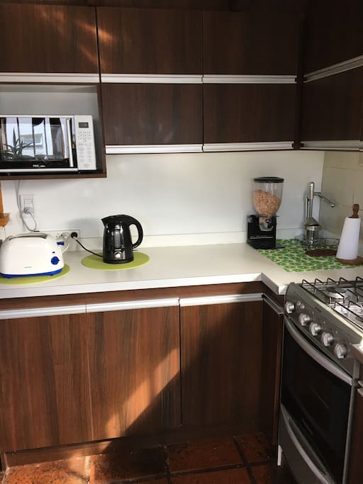 Cocina completa con vajilla, electrodomésticos, lavadora de ropa y heladera con freezer