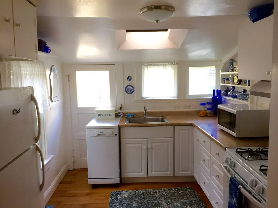 The kitchen is small, but functional with plenty of dishes and cookware.