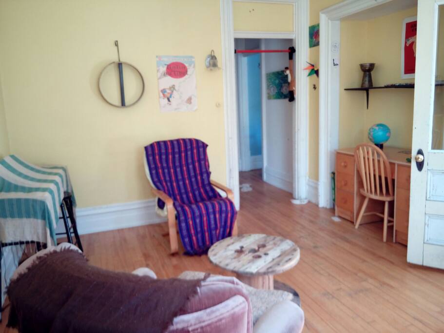 Cozy living room with desk, dining table and electric piano.