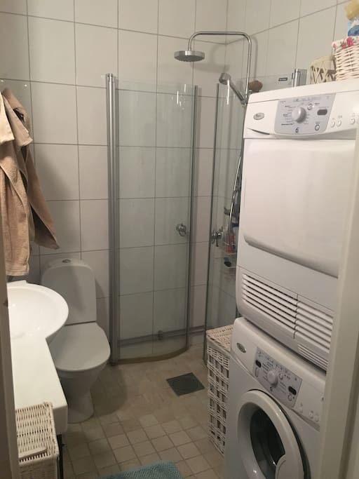 Bathroom with shower, washing machine and tumble dryer