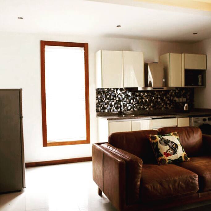 Living room with luxury leather couch comes with 50 inch tv, fridge and other amenities
