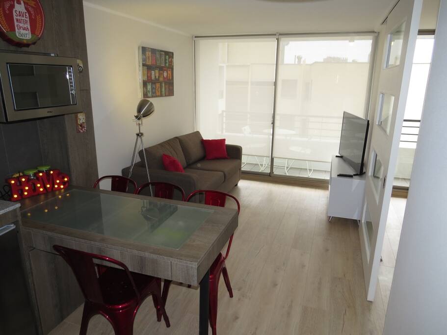 Cocina americana full equipada y living con sillón cama de 2 plazas y TV 48".