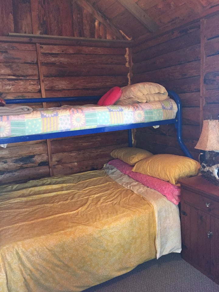 The second bedroom in the sleeping cabin has the original split log interior & sleeps 3. 