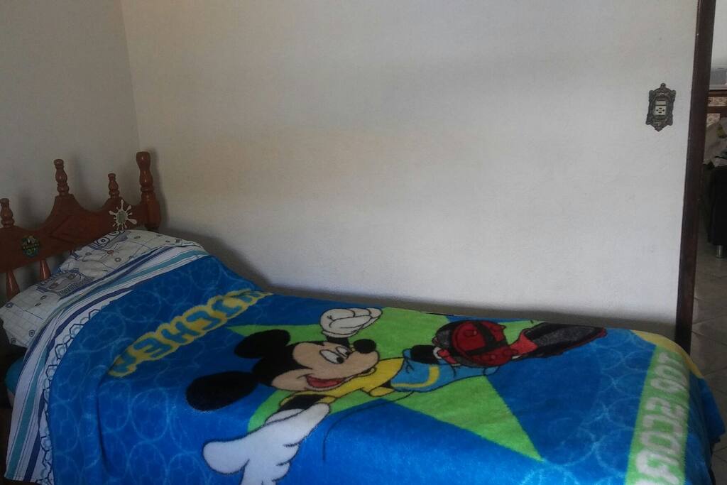 Cama de solteiro com duas gavetas. Quarto amplo.