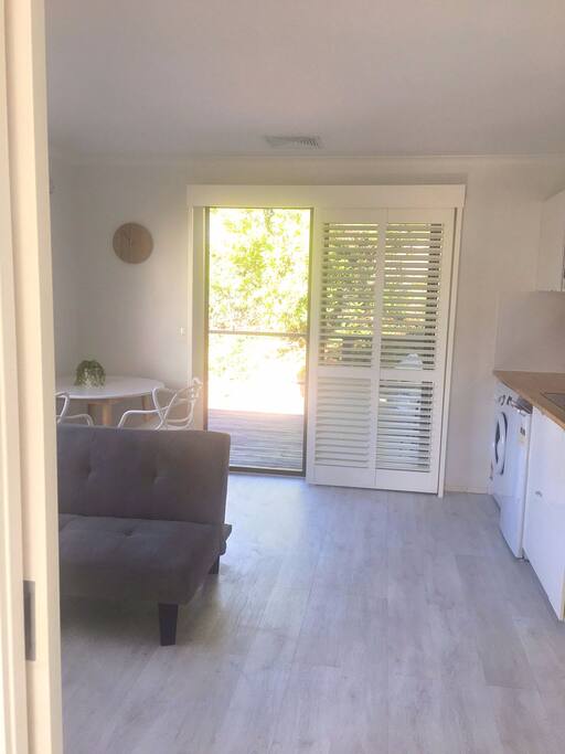 Open plan kitchen and lounge including a range of cooking appliances and personal washing machine
