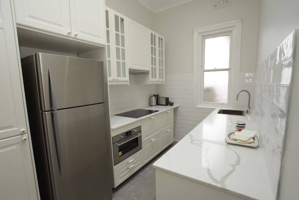 Kitchen newly renovated with oven, stovetop, toaster, kettle and utensils
