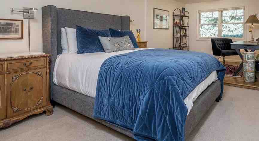 חדר שינה ראשי בקומת המגורים הראשית, אשוחית כחולה גדולה בחלון הקדמי עם חלל משרדי נוח. חלון המשרד משקיף על המרפסת הקדמית. 