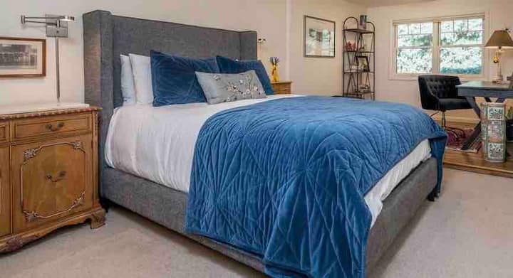 Hlavná spálňa na hlavnom obývacom poschodí, veľký modrý smrek pred predným oknom s pohodlným kancelárskym priestorom. Okno kancelárie s výhľadom na prednú verandu. 