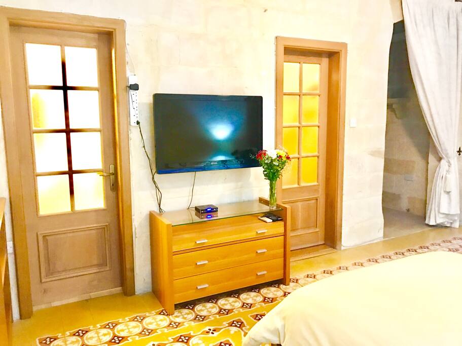Large double bedroom with ensuite bathroom. traditional Maltese floor tiles and large flatscreen TV
