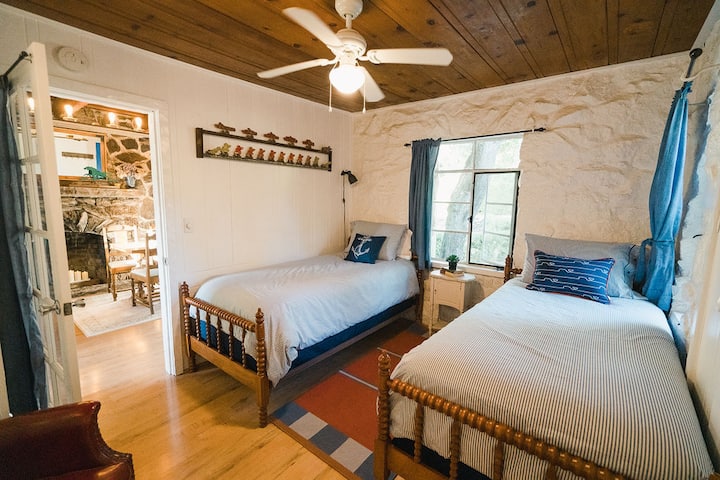 The Twin Room features two twin beds and a cozy chair. It's just off the living room, and has a door leading to the main bathroom.