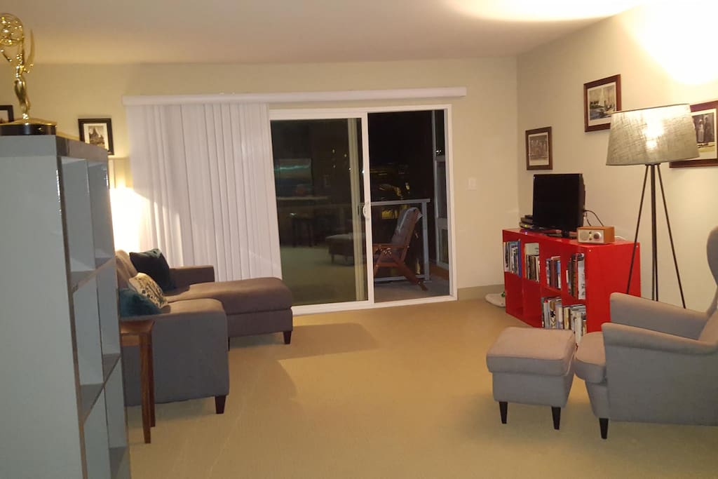 Large living room with Smart T.V. (amazon prime and netflix), cable, radio, reading chair, couch, outdoor patio with dining area, access to books and games, and a den area to the right!
