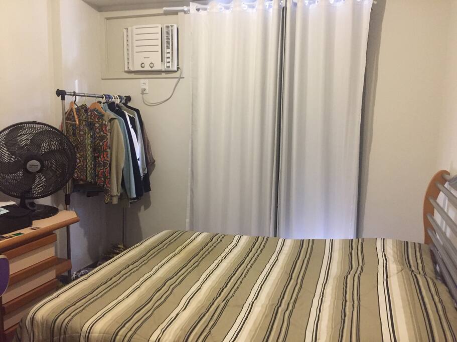 Ar condicionado, ventilador, cama de casal, arara e mesa para estudo/leitura.